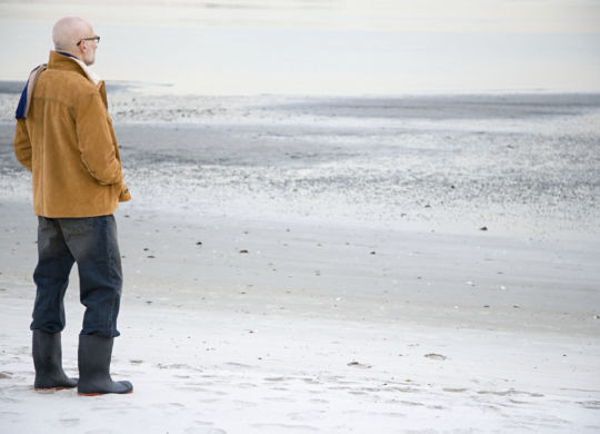 Mature man standing on an empty beach