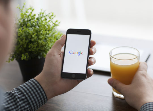 Alushta, Russia - November 21, 2014: Man holding a iPhone 6 Space Gray with social networking service Google on the screen. iPhone 6 was created and developed by the Apple inc.