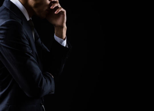 This is a photograph of a depressed businessman on black background