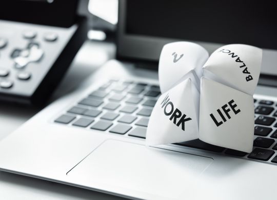 Origami fortune teller on laptop in office concept for work life balance choices